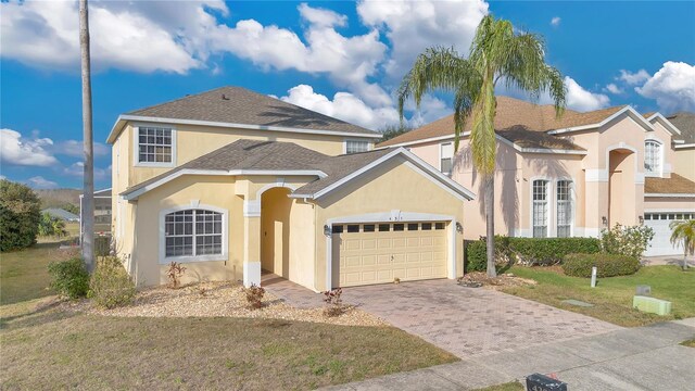 view of front of house featuring a garage, a front lawn, and stucco siding