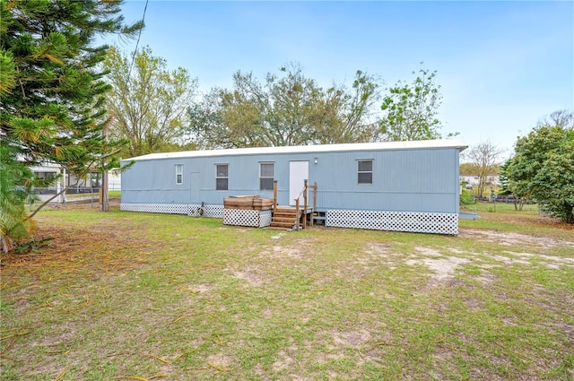 rear view of property with fence and a lawn