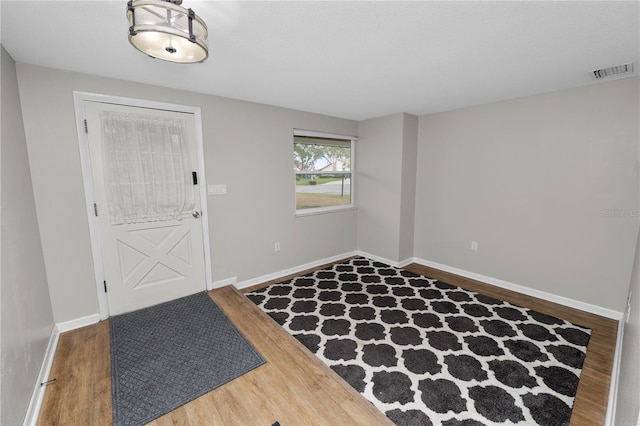 entryway with wood finished floors, visible vents, and baseboards