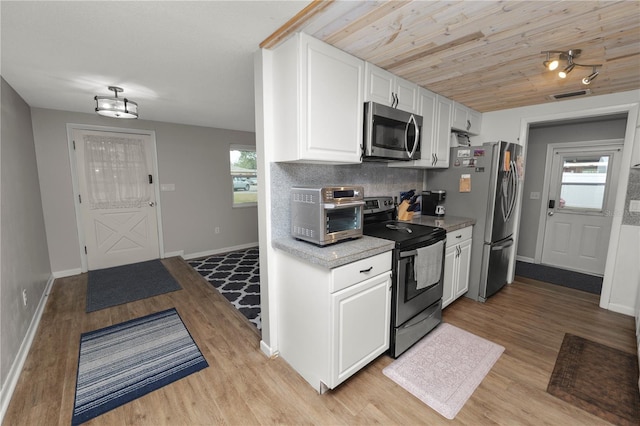 kitchen with a toaster, visible vents, white cabinetry, light countertops, and appliances with stainless steel finishes