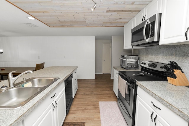 kitchen featuring stainless steel appliances, a sink, white cabinetry, light countertops, and light wood-type flooring