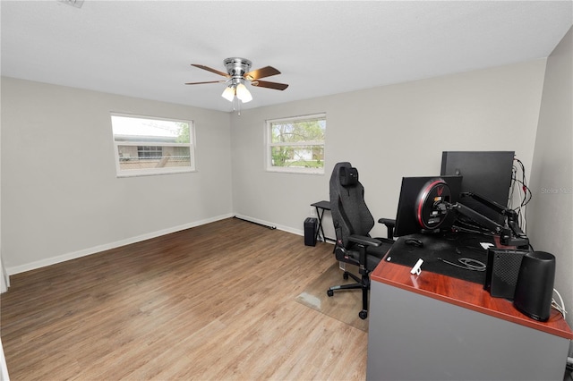 office space featuring light wood-style floors, baseboards, and a ceiling fan