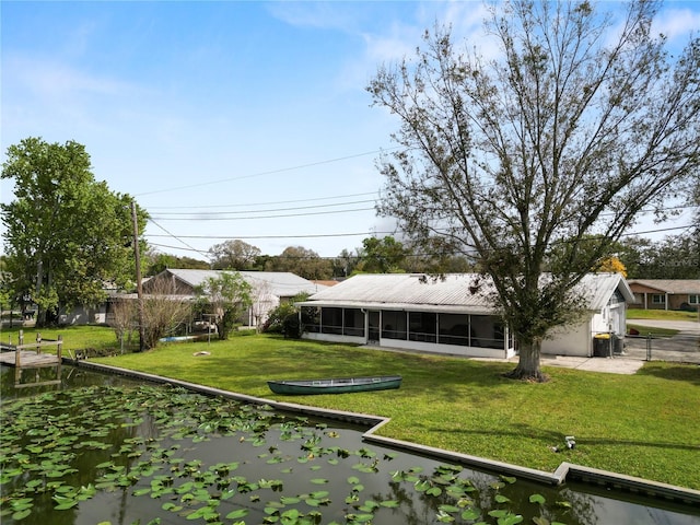 rear view of house featuring a residential view, a sunroom, and a lawn