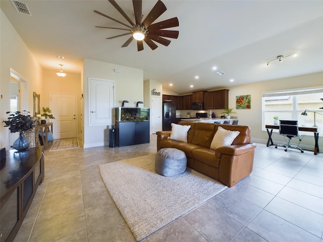 living area featuring vaulted ceiling, light tile patterned floors, visible vents, and recessed lighting