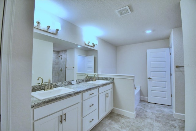 full bathroom with double vanity, a shower stall, visible vents, and a sink