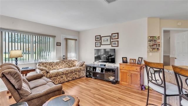 living room featuring light wood-style flooring and visible vents