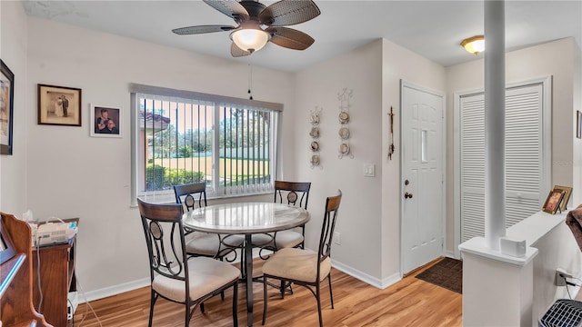 dining area with light wood-style floors, ceiling fan, and baseboards