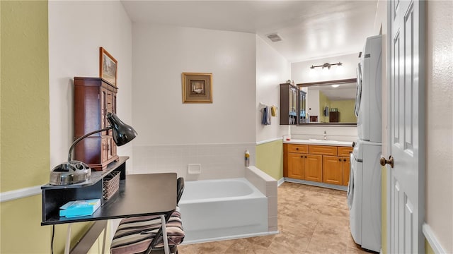 full bathroom featuring tile patterned flooring, stacked washer / dryer, visible vents, vanity, and a bath