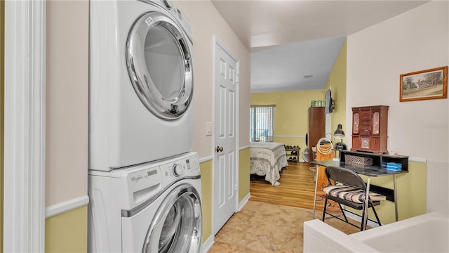 washroom with stacked washer and dryer and laundry area