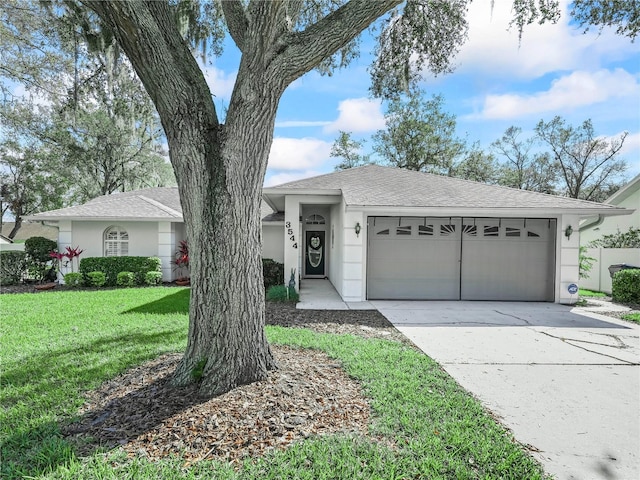 ranch-style house with roof with shingles, stucco siding, a front yard, a garage, and driveway