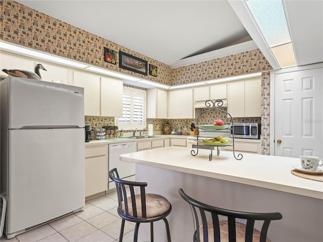 kitchen with white appliances, light tile patterned floors, light countertops, and backsplash