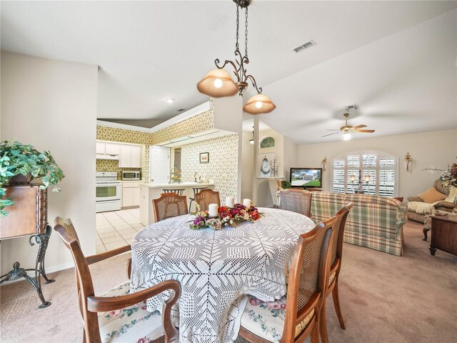 dining room featuring ceiling fan, wallpapered walls, visible vents, and light colored carpet