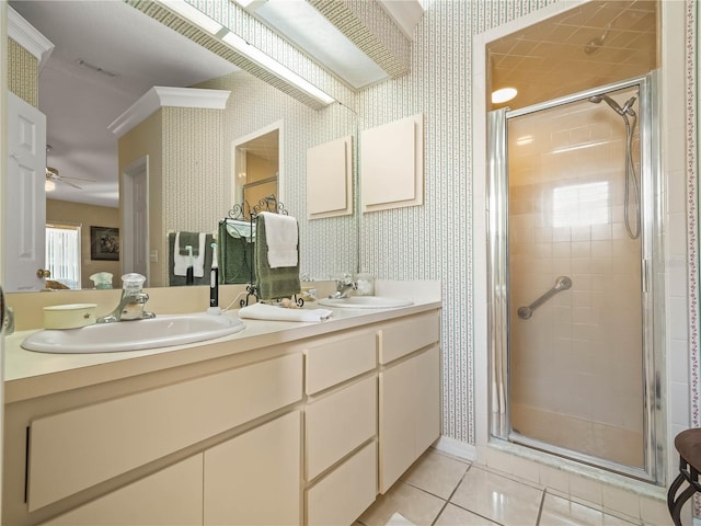 bathroom with a stall shower, tile patterned floors, a sink, and wallpapered walls