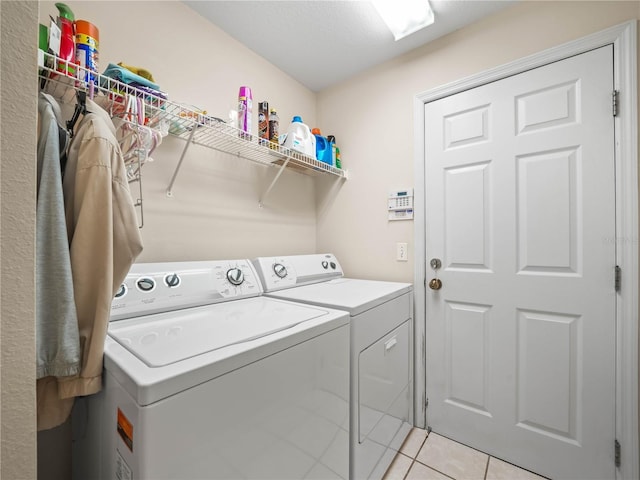 washroom with laundry area, washing machine and clothes dryer, and light tile patterned floors