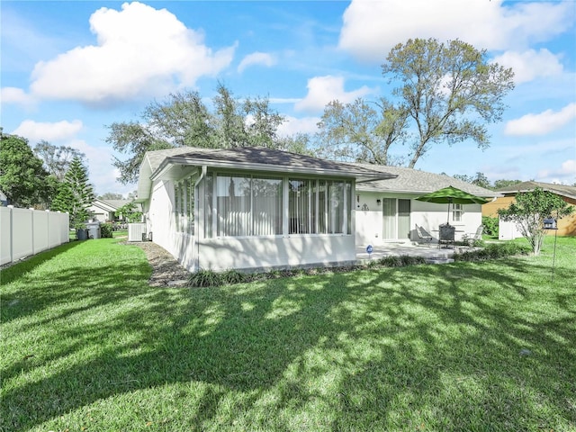 rear view of house with a patio area, a lawn, and fence