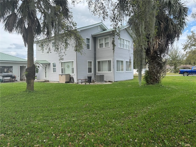 exterior space with central AC and a yard