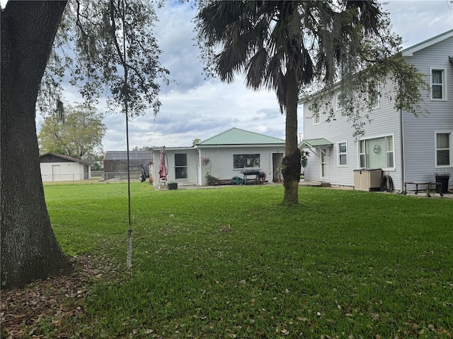 rear view of house featuring a lawn and fence