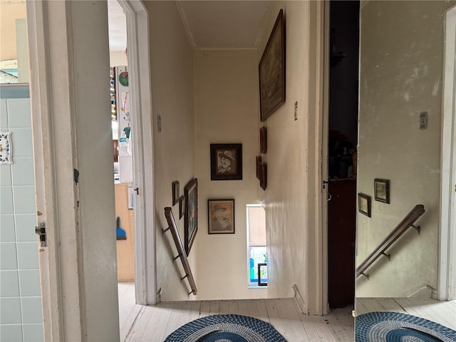 hall featuring light wood-style floors and an upstairs landing