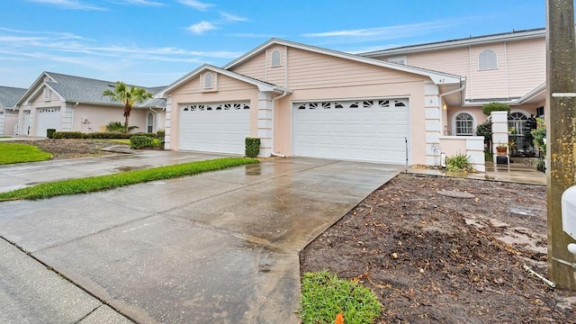 view of front of property with an attached garage, concrete driveway, and stucco siding