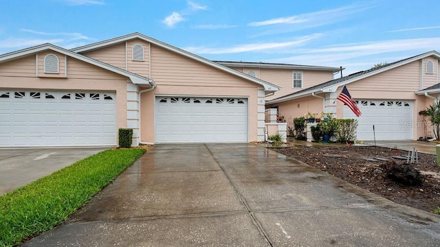 view of front facade with driveway, an attached garage, and stucco siding