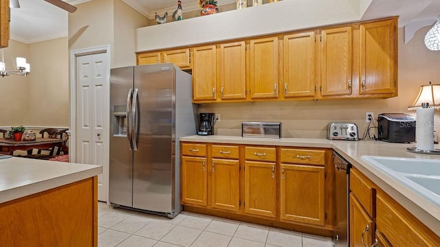 kitchen featuring appliances with stainless steel finishes, light countertops, hanging light fixtures, and crown molding