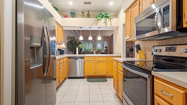 kitchen with stainless steel appliances, light countertops, hanging light fixtures, and visible vents