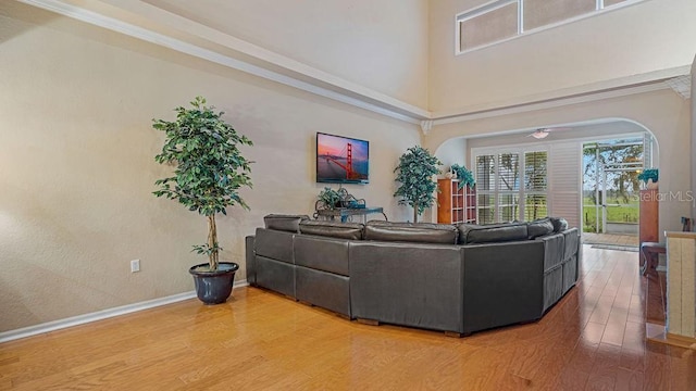 living room featuring a high ceiling, wood finished floors, and baseboards