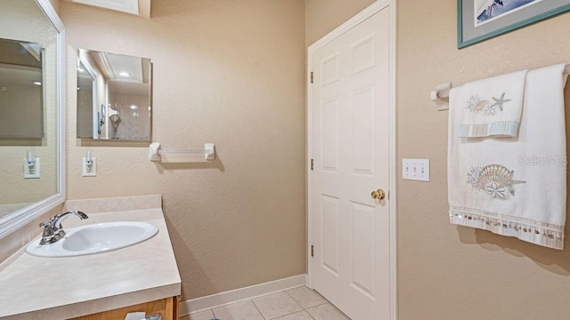 bathroom featuring vanity, baseboards, and tile patterned floors