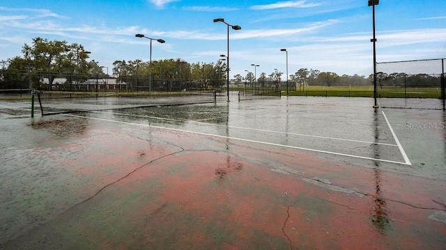 view of tennis court featuring fence