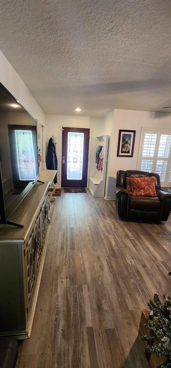 entryway featuring dark wood-style floors and a textured ceiling