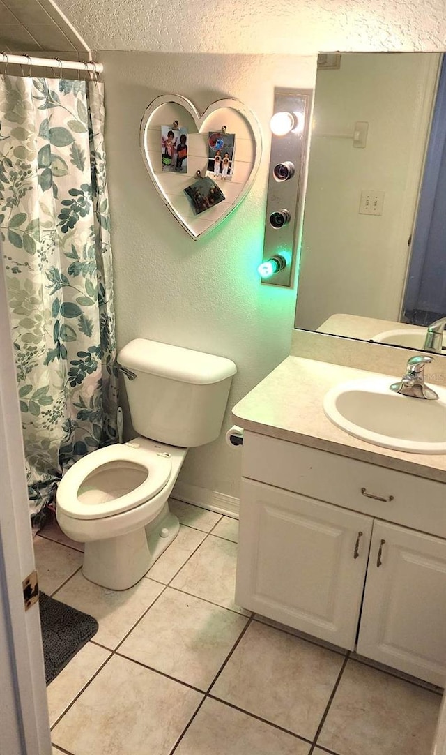 bathroom featuring toilet, curtained shower, tile patterned flooring, a textured ceiling, and vanity