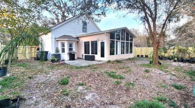 back of house featuring a patio, fence, and a sunroom