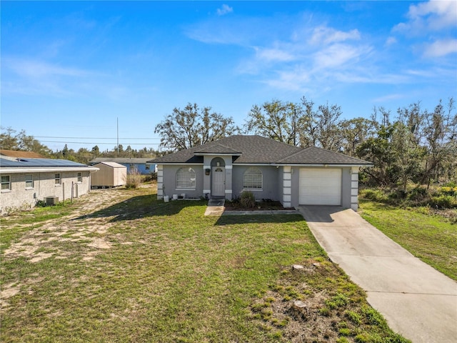 single story home featuring stucco siding, a storage unit, concrete driveway, an attached garage, and a front yard