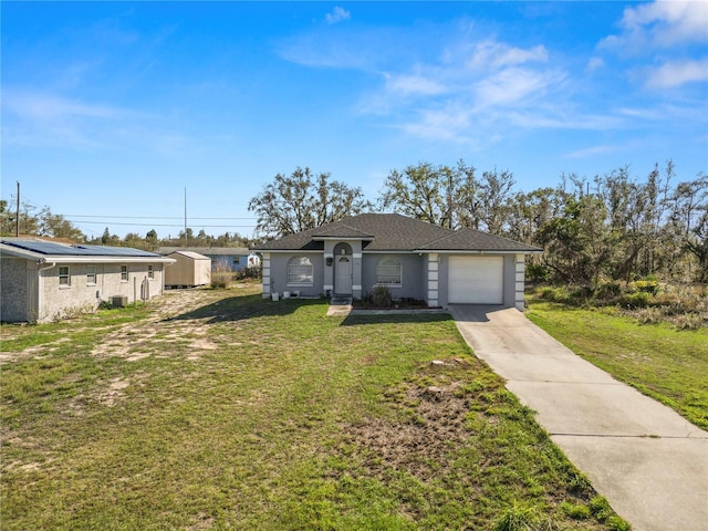 ranch-style home featuring a garage, driveway, a front lawn, and a shed