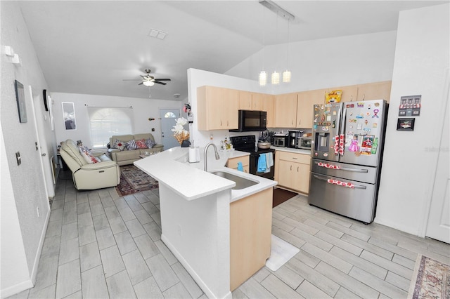 kitchen with light countertops, open floor plan, light brown cabinets, a peninsula, and black appliances