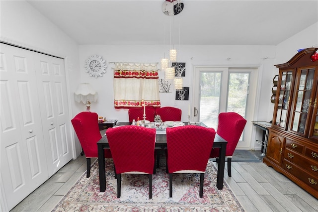 dining area with lofted ceiling and wood tiled floor