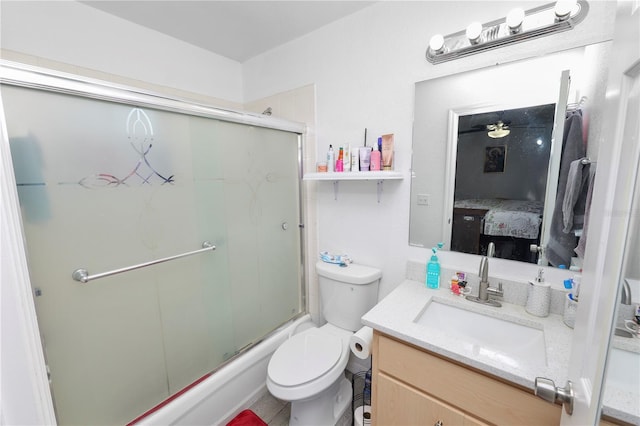 ensuite bathroom with toilet, combined bath / shower with glass door, connected bathroom, and vanity