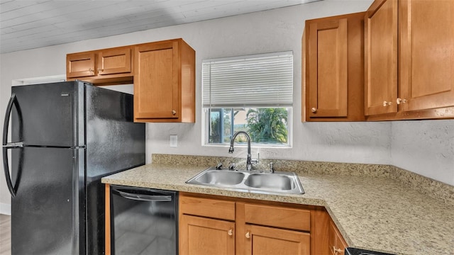 kitchen with light countertops, black appliances, a sink, and brown cabinets