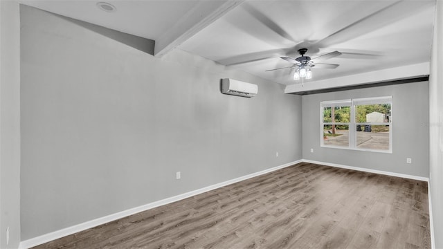 spare room featuring ceiling fan, wood finished floors, baseboards, an AC wall unit, and beamed ceiling