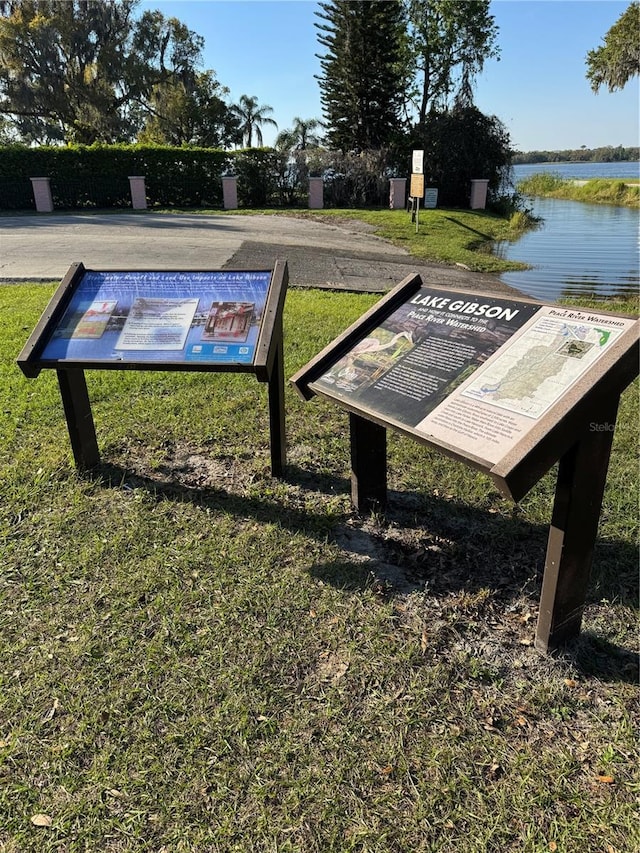 view of property's community with a yard and a water view