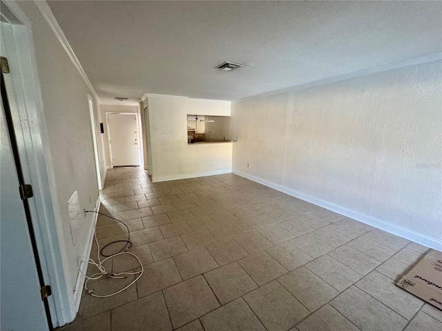 spare room featuring visible vents, baseboards, and crown molding