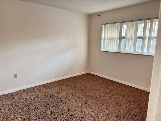 carpeted empty room with baseboards