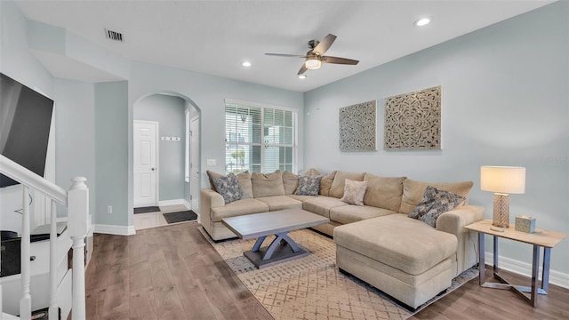 living area with recessed lighting, wood finished floors, visible vents, baseboards, and stairs