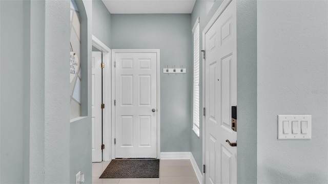 entryway featuring light tile patterned flooring and baseboards