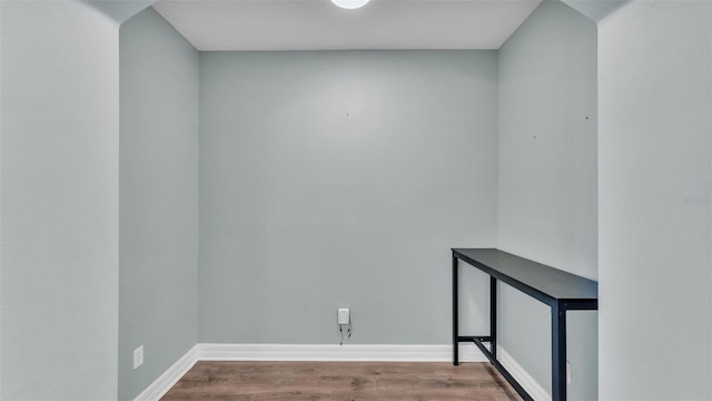 unfurnished room with baseboards and wood finished floors