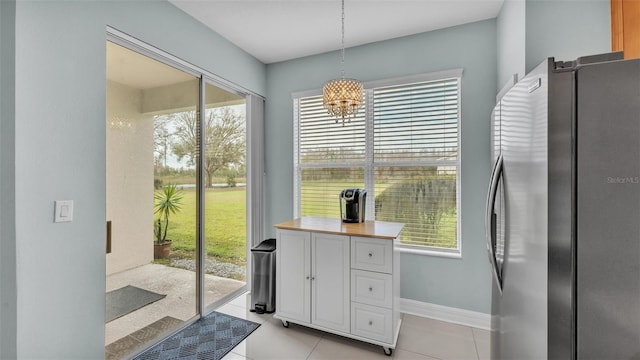 entryway with light tile patterned flooring and baseboards