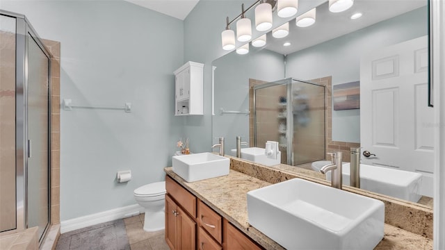 bathroom featuring a stall shower, a sink, and toilet