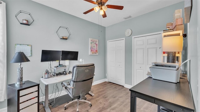 home office featuring visible vents, ceiling fan, baseboards, and wood finished floors