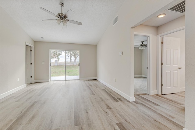 spare room featuring a textured ceiling, ceiling fan, light wood-style flooring, and visible vents