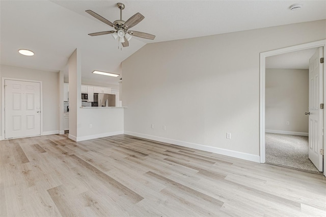 unfurnished living room with light wood-style floors, vaulted ceiling, ceiling fan, and baseboards